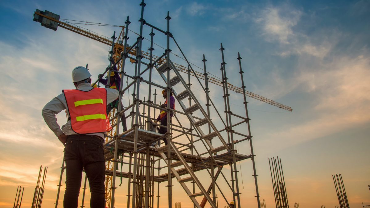 trabajadores que instalan barandillas en los andamios para cumplir los requisto la OSHA en materia protección contra caídas