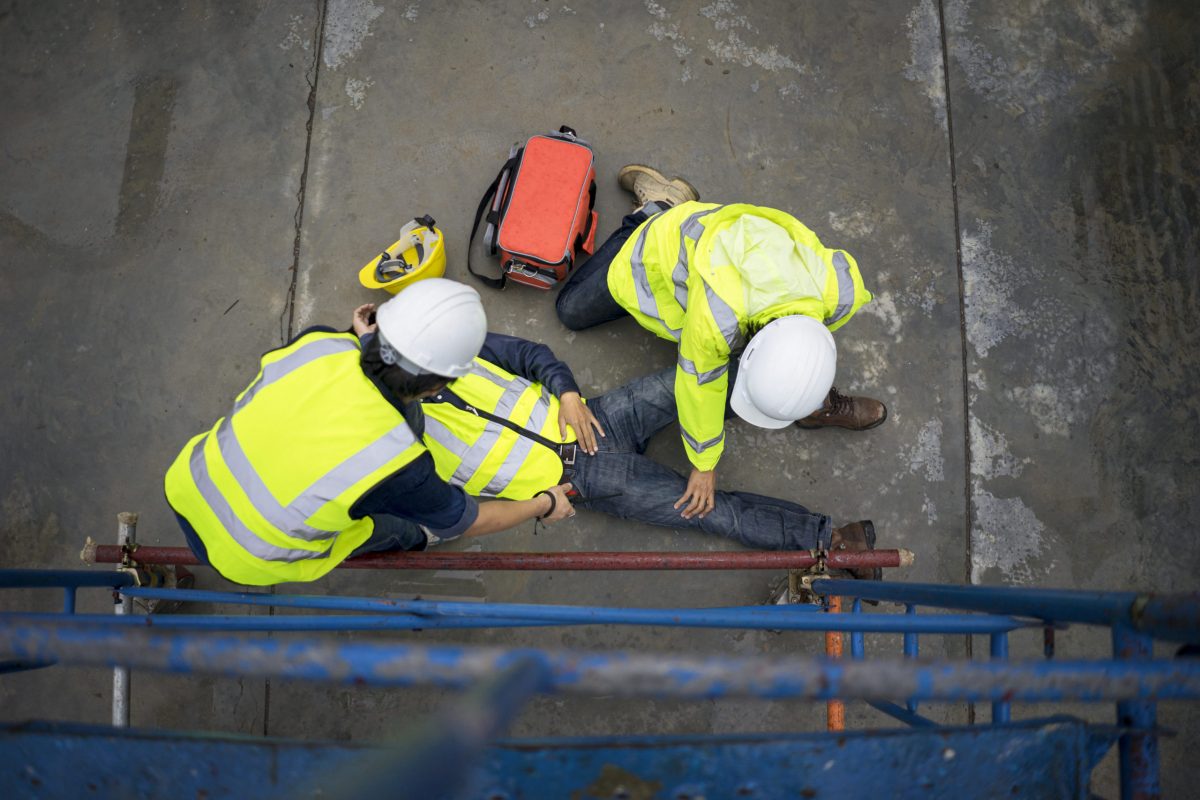 基本急救培训支持事故在现场工作，建设者事故坠落脚手架到地板，安全团队帮助员工事故。