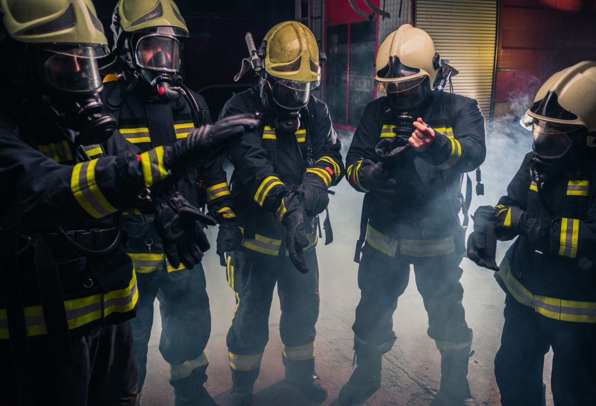消防部门的消防队员们戴着防毒面具，穿着制服